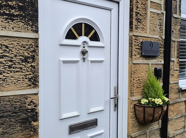 A front door with a nameplate at Cliffe Cottage Brotton, North Yorkshire