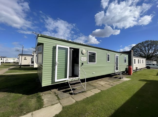 A mobile home with a green exterior and steps at 214 Oaklands Area