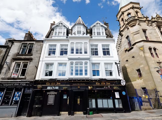 A pub building with multiple windows and entrance at The Old Inn in 