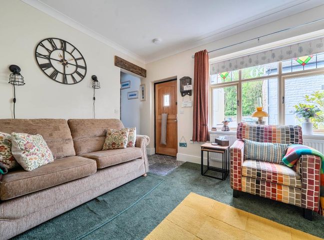 A living room with a sofa and armchair at 20 Main Street in Heysham