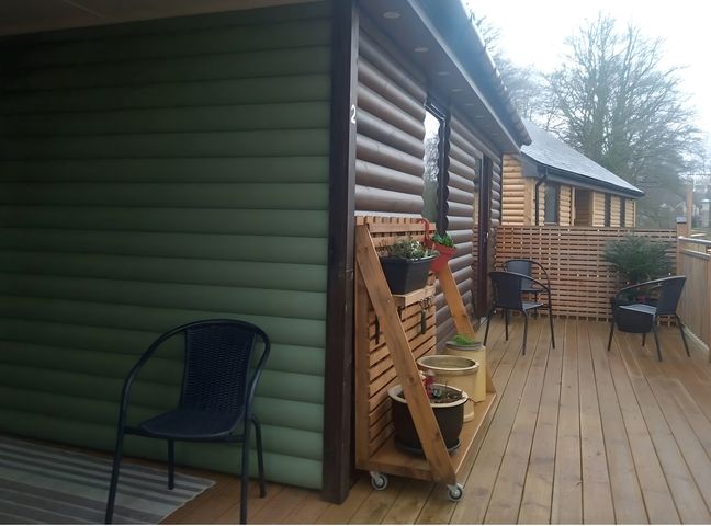 An outdoor area with flower pots and chairs at Gowrie Lodge in Blairgowrie