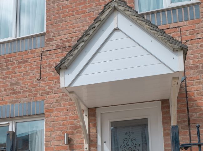 A roof over a doorway with a brick wall at Rochester Road Corby