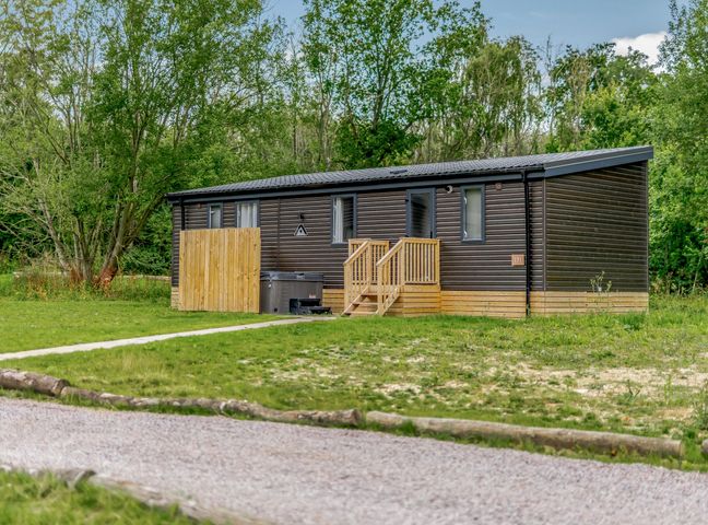 A wooden cabin with steps and decking at Horncastle Spa Plus in Louth