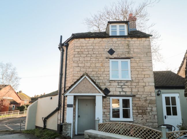 A house with stone walls and multiple windows at The Corner Cottage in Gloucester