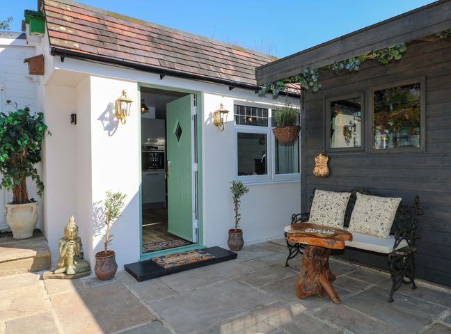 An outdoor area with a bench and potted plants at Shell Cottage in Bournemouth