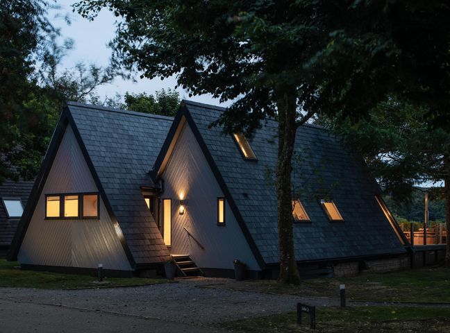 An exterior view of a house with multiple windows and a pathway at St Ives Lodge 3 Spa in Praze-An-Beeble