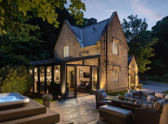 An outdoor seating area with a hot tub and a house at The Gatehouse in Praze-An-Beeble