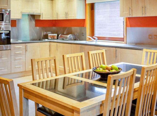 A kitchen with a dining table and chairs at Woodland Lodge Spa in Praze-An-Beeble