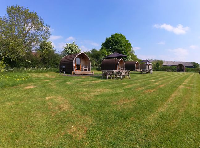 Outdoor pods with tables and chairs at Rosebud Meadow Pod 4 in Malvern