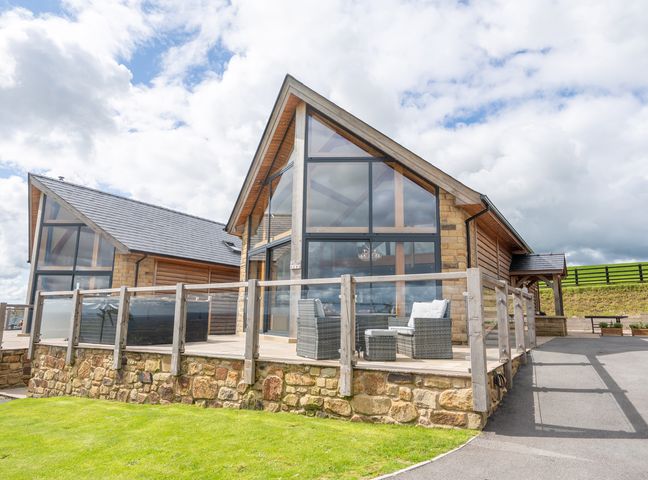 A building with large windows and a deck at Valley View Lodge 1 Preston