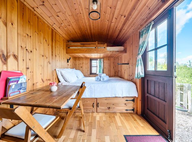 A bedroom with a bed and table at Bryn Mawr Cabin in Clun