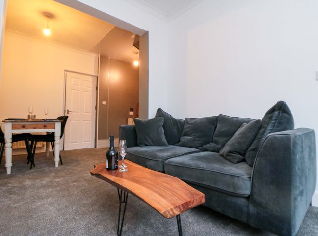 A living room with a sofa and dining table at Isla’s Sea Forge Saltburn-by-the-Sea