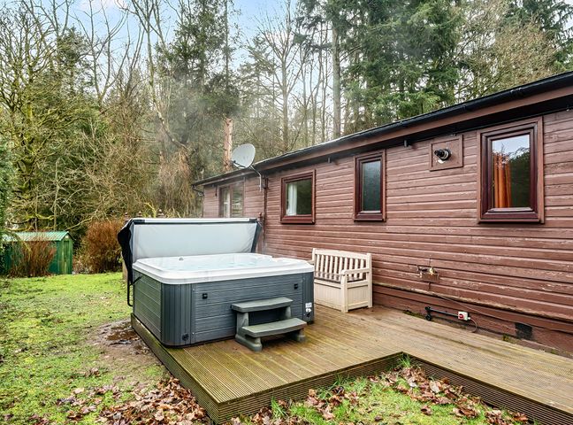 An outdoor area with a hot tub and wooden deck at Cabin 1 Moffat Manor in Beaufort