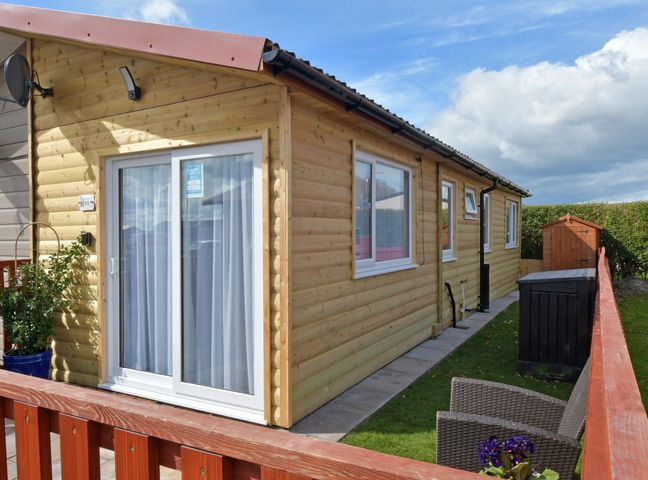 A cabin with patio furniture and a garden shed at 228b Eighth Avenue in Bridlington