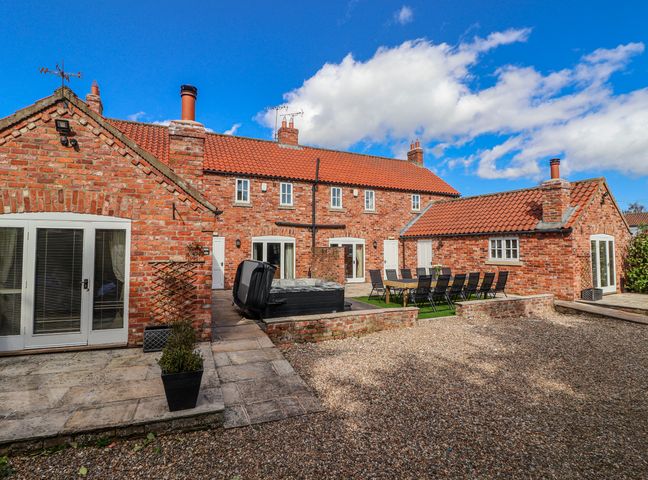 An outdoor area with a table and chairs at Champagne Cottage Weaverthorpe