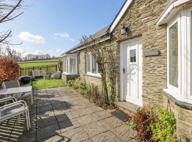 An outdoor area with a door and patio at Glanyrafon Smithy in New Quay