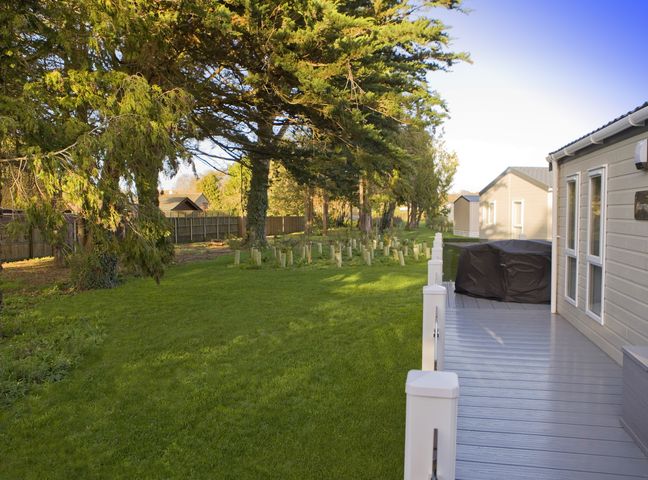 An outdoor area with a deck and grass in Orchid 9 Christchurch