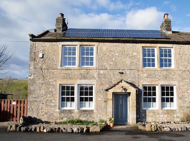 A stone house with solar panels and a garden at Kirk Yett in Linton Falls near Skipton