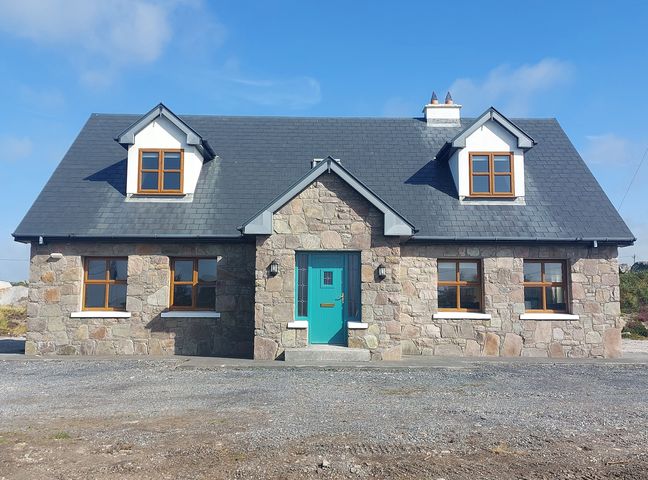 A house with stone facade and a teal door at Tigh Marie