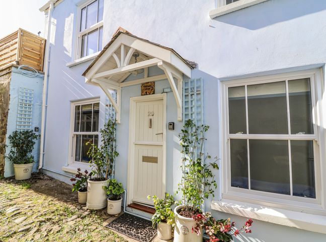 A front entrance with door and plants at Hideaway Cottage