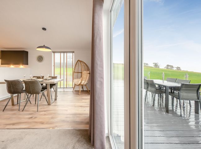 A dining room with a table and chairs at Sonnet 3 Spa Carmarthen