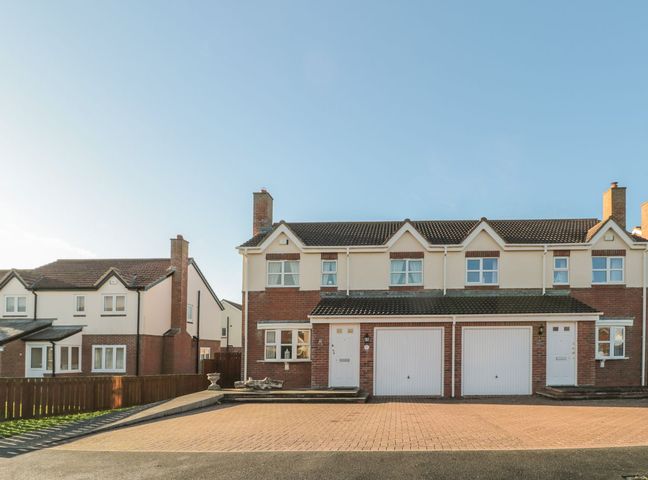 A house with a driveway and garages at Sandy Cove in Chathill