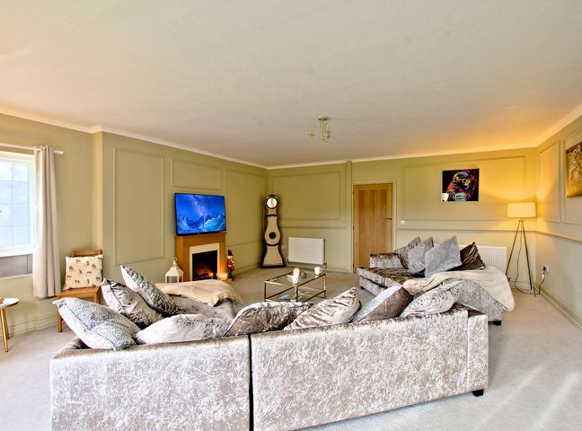 A living room with a sofa and television at River View Cottage, Hanlith near Malham
