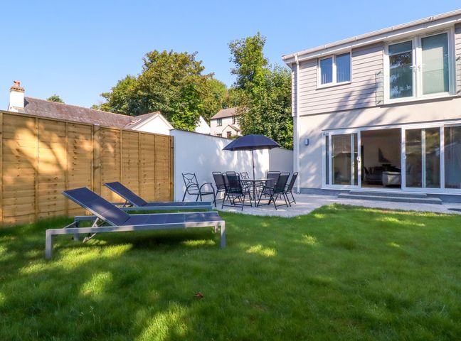 A garden with sun loungers and a dining set at Creek Lodge Chacewater