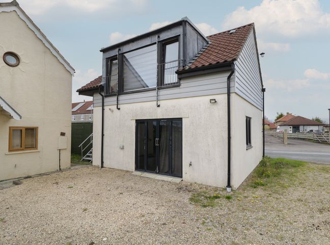An outdoor view of a house with a balcony at The Nest in Meare near Glastonbury