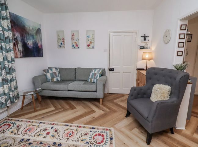 A living room with a sofa and armchair at 55 Meldon terrace Newbiggin-by-the-Sea