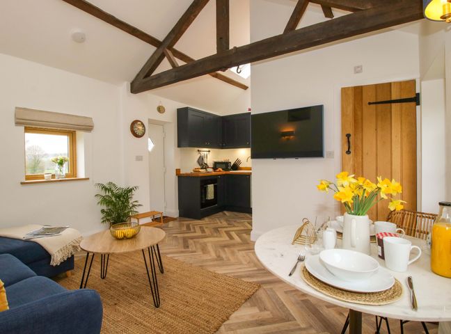 A living room with a dining area and kitchen unit at The Blacksmiths Shop 