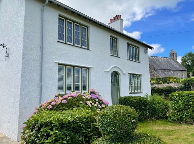 A house with a garden and bushes at Ty Mawr Farm in Llanfairpwllgwyngyll
