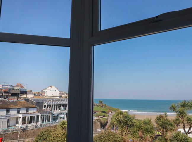 A view from a window showing ocean and beach at Sea View in Newquay