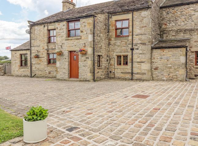 An outdoor area with a stone house and a planter at Orcaber Farmhouse Lancaster