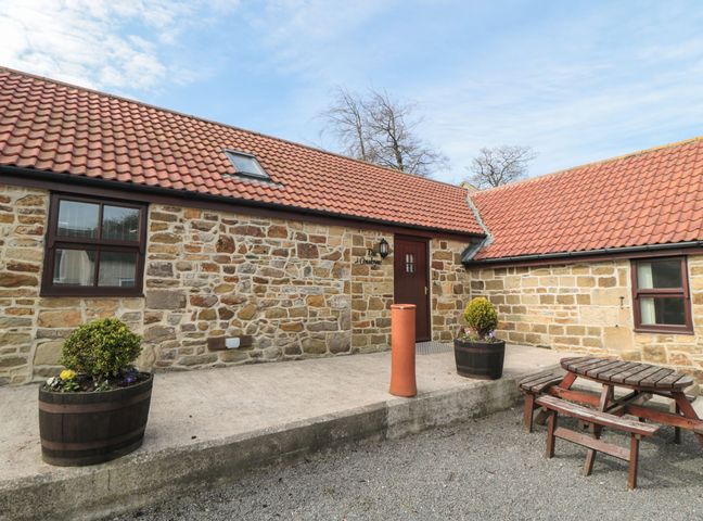 An outdoor area with a stone building and planters at The Cow Byre in Lingdale