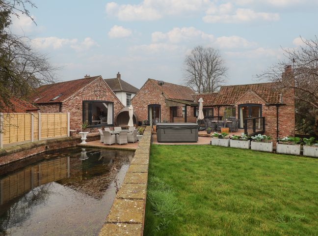 An outdoor area with houses and patio furniture at Mill Race Cottage in Driffield