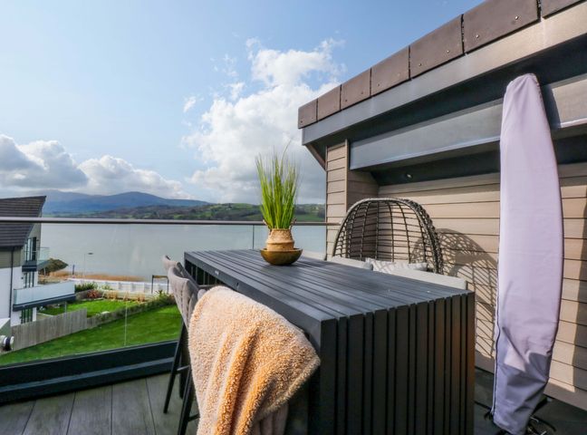 A balcony with a table and planter at 2 Glan Yr Aber in Colwyn Bay