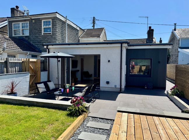 A house with a patio furniture and garden at Y Bwthyn Pembrey