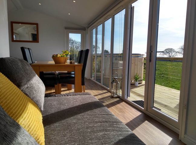 A dining room with a table and chairs at Cleeves Cabins 1, Ailsa Luxury Lodge with hot tub, St. John's Town Of Dalry