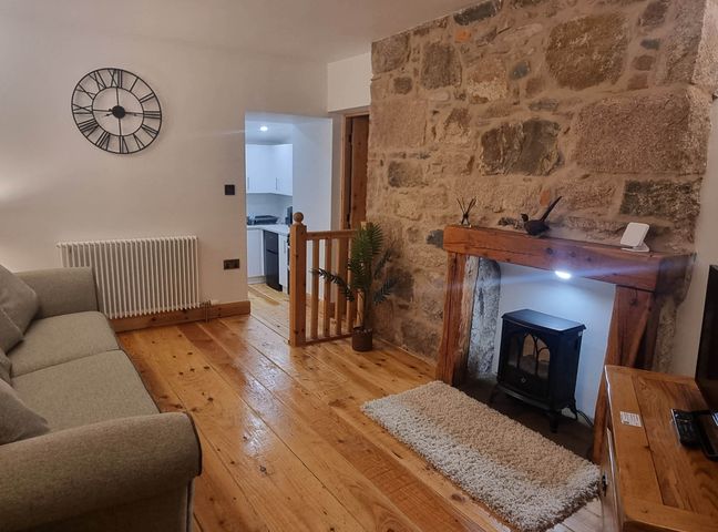 A living room with a sofa and a fireplace at The Coal Office, Aberlour