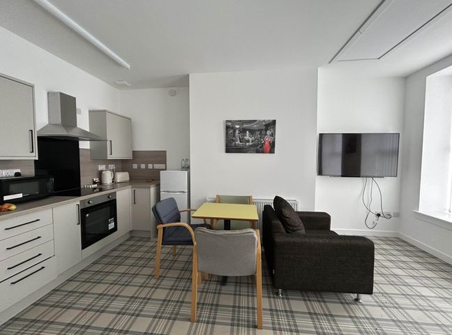 A living room with kitchen units and a table at Buckie Haven 3 Bed Contractors Business Travellers in Buckie