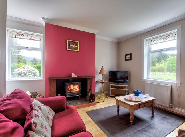 A living room with a fireplace and a television at Argyll Farmhouse-Idyllic Setting-Sleeps10 in Dunoon