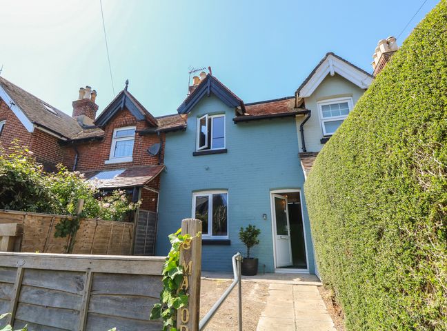 A house with windows and a door surrounded by a hedge at 8 Manor Villas Totland Bay