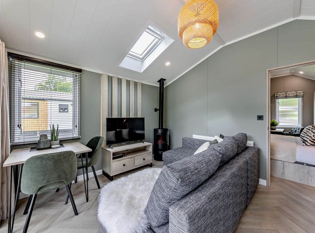 A living room with a sofa and television at Prion 1.0 Pet in Llandyrnog