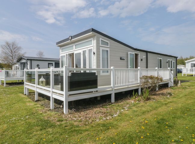 A mobile home with a deck in the outdoor area at Swan Haven in Grange-Over-Sands