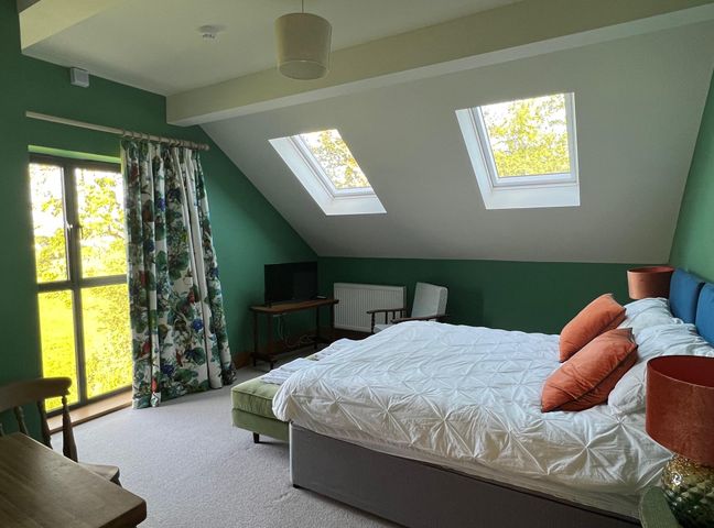 A bedroom with a bed and windows at 2 Guests Studio - Free Parking - Stunning Views near Bruton