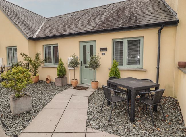 A table and chairs in a gravel area at Cornstore Cottage in Pembroke