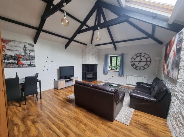 A living room with a sofa, chairs, table, and television at the property