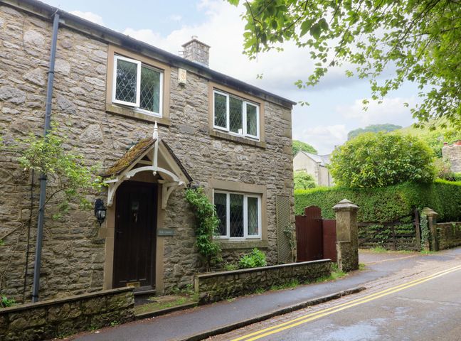 A stone house with windows and a door at The Chimes in Hope Valley