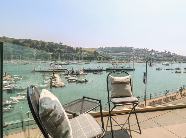 A balcony with chairs overlooking a harbor at 5 Sails in Dartmouth